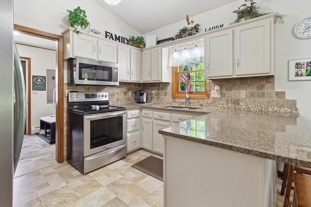 10343 N Walnut Ave, Bitely, MI 49309 - kitchen with stainless steel appliances, a peninsula, backsplash, light stone counters, and white cabinets