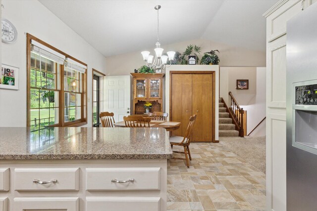 10343 N Walnut Ave, Bitely, MI 49309 - kitchen with a chandelier, lofted ceiling, stainless steel fridge with ice dispenser, white cabinets, and light stone counters
