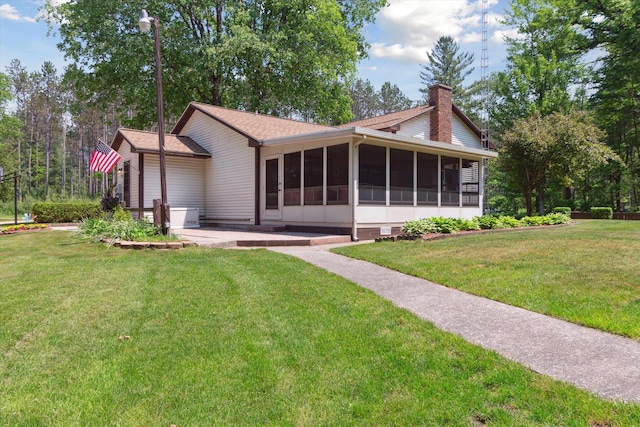 10343 N Walnut Ave, Bitely, MI 49309 - rear view of property featuring a sunroom, a chimney, a lawn, and roof with shingles