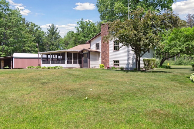 10343 N Walnut Ave, Bitely, MI 49309 - back of property featuring a sunroom, a lawn, and a chimney
