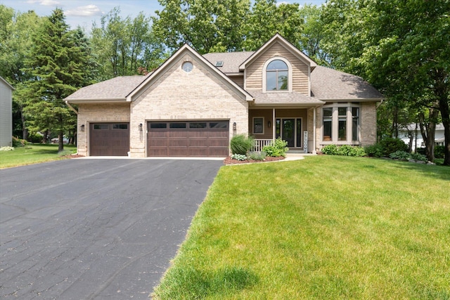 5326 Saddle Club Dr, Kalamazoo, MI 49009 - view of front of house with an attached garage, a front yard, asphalt driveway, and brick siding