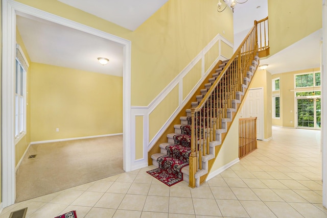 2032 Cameo Ct, Canton, MI 48187 - staircase featuring tile patterned flooring, a towering ceiling, and carpet flooring