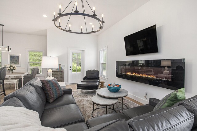 7285 Maple St, South Haven, MI 49090 - living room with a chandelier, wood finished floors, and a glass covered fireplace