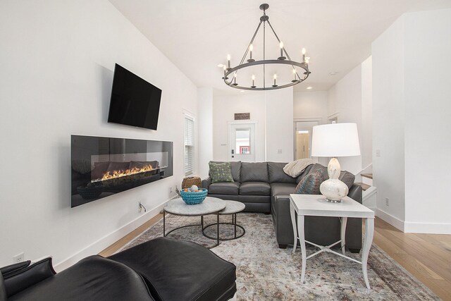 7285 Maple St, South Haven, MI 49090 - living room featuring a chandelier, wood finished floors, a glass covered fireplace, and recessed lighting