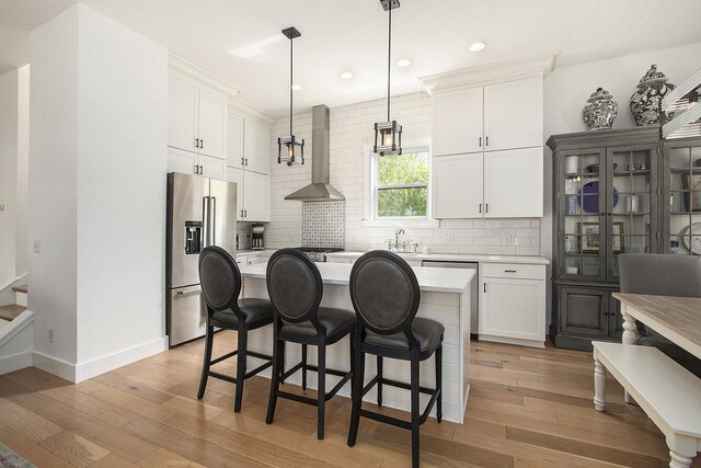 7285 Maple St, South Haven, MI 49090 - kitchen with high end fridge, wall chimney range hood, light countertops, backsplash, and recessed lighting