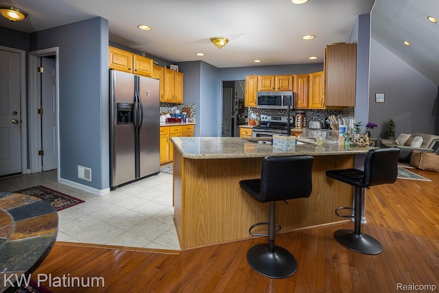 3167 Blackheath Ct, Port Huron, MI 48060 - kitchen with stainless steel appliances, a peninsula, decorative backsplash, light stone counters, and recessed lighting