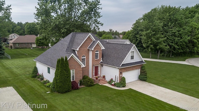 3167 Blackheath Ct, Port Huron, MI 48060 - traditional-style house featuring a shingled roof, driveway, a front yard, and brick siding