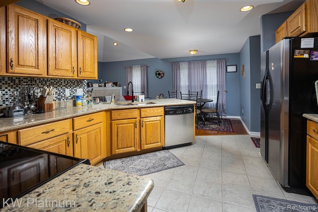 3167 Blackheath Ct, Port Huron, MI 48060 - kitchen featuring appliances with stainless steel finishes, light tile patterned floors, a peninsula, decorative backsplash, and brown cabinets