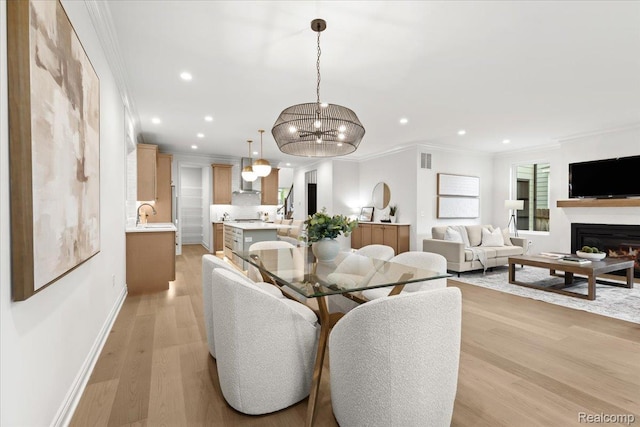 624 S Vermont Ave, Royal Oak, MI 48067 - dining area featuring ornamental molding, recessed lighting, a chandelier, light wood finished floors, and a glass covered fireplace