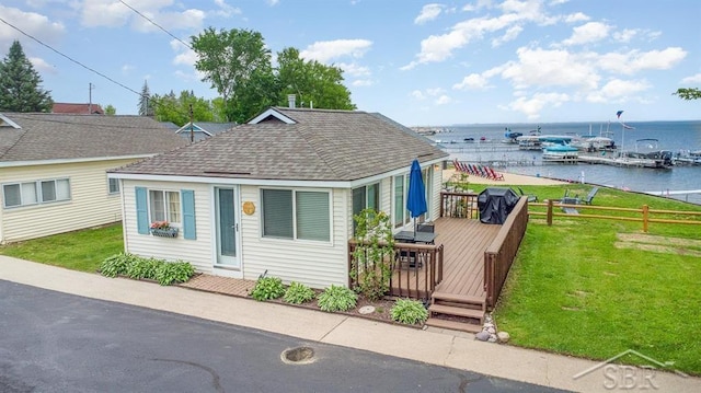 6276 W Houghton Lake Dr, Houghton Lake, MI 48629 - view of front of property with roof with shingles, a deck with water view, and a front lawn