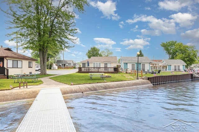 6276 W Houghton Lake Dr, Houghton Lake, MI 48629 - back of house featuring a water view, a residential view, and a lawn