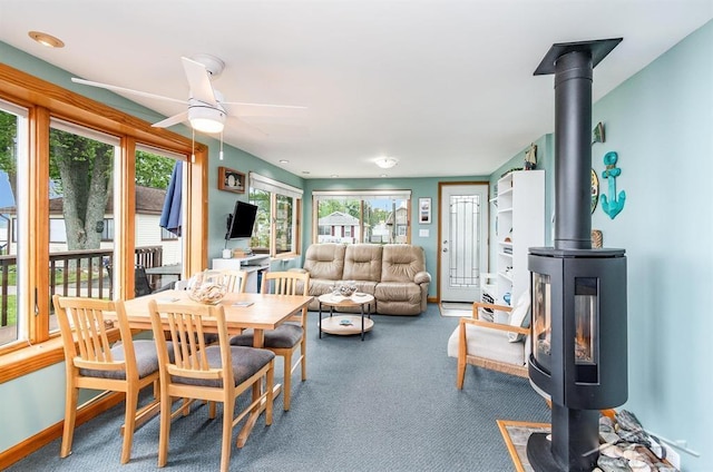 6276 W Houghton Lake Dr, Houghton Lake, MI 48629 - carpeted dining space featuring a wood stove and ceiling fan