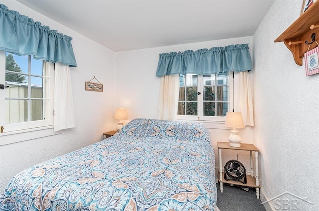 6276 W Houghton Lake Dr, Houghton Lake, MI 48629 - carpeted bedroom featuring multiple windows and a textured wall