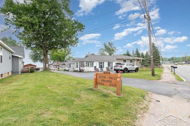 6276 W Houghton Lake Dr, Houghton Lake, MI 48629 - view of front facade with a front lawn and asphalt driveway