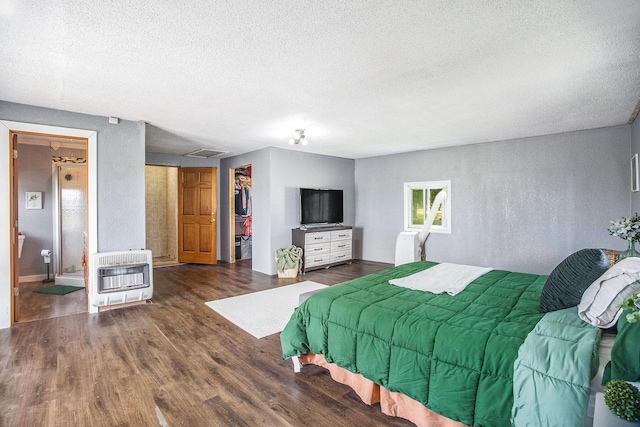 3463 Arthur Rd, Remus, MI 49340 - bedroom with heating unit, a textured ceiling, a walk in closet, wood finished floors, and a closet