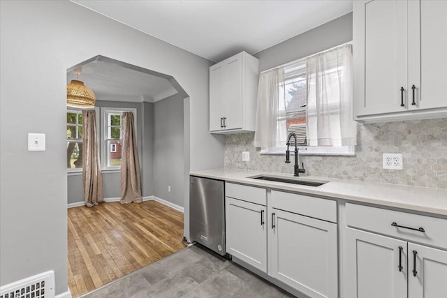 22406 Colony St, Saint Clair Shores, MI 48080 - kitchen with stainless steel dishwasher, decorative backsplash, light countertops, and arched walkways