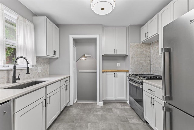 22406 Colony St, Saint Clair Shores, MI 48080 - kitchen featuring appliances with stainless steel finishes, light countertops, backsplash, and white cabinetry