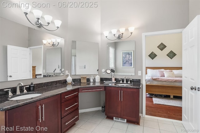 9806 Goldfinch Ct, Saline, MI 48176 - ensuite bathroom featuring a chandelier, tile patterned flooring, double vanity, and a high ceiling