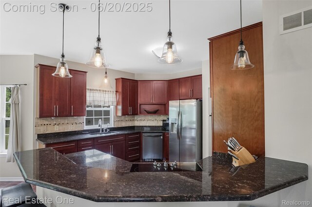 9806 Goldfinch Ct, Saline, MI 48176 - kitchen with stainless steel appliances, decorative backsplash, dark brown cabinets, and decorative light fixtures