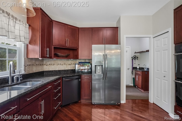 9806 Goldfinch Ct, Saline, MI 48176 - kitchen with appliances with stainless steel finishes, dark brown cabinets, dark wood-style floors, and dark stone counters
