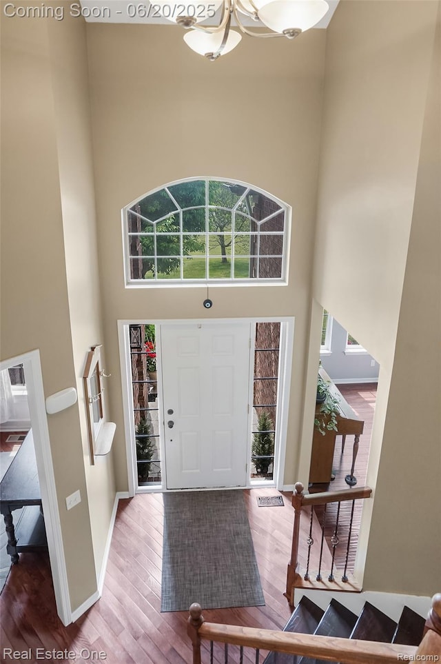9806 Goldfinch Ct, Saline, MI 48176 - entrance foyer featuring a high ceiling, wood finished floors, and a chandelier