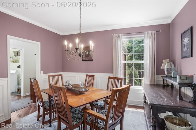 9806 Goldfinch Ct, Saline, MI 48176 - dining area with light wood-type flooring, a chandelier, ornamental molding, a wainscoted wall, and washer / dryer