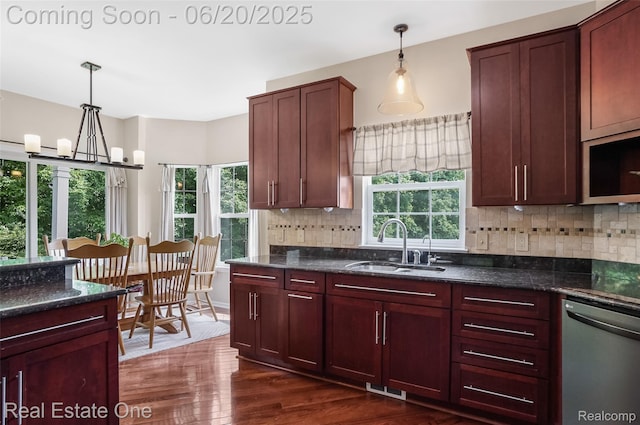 9806 Goldfinch Ct, Saline, MI 48176 - kitchen with dishwasher, decorative backsplash, dark wood finished floors, a chandelier, and pendant lighting