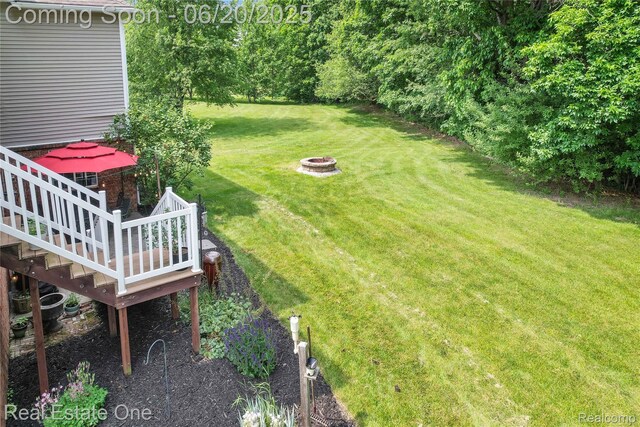 9806 Goldfinch Ct, Saline, MI 48176 - view of grassy yard with a fire pit and a wooden deck