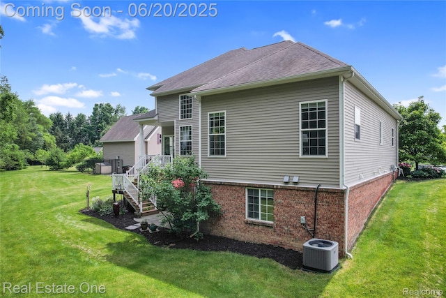 9806 Goldfinch Ct, Saline, MI 48176 - rear view of house with a yard, brick siding, and a shingled roof
