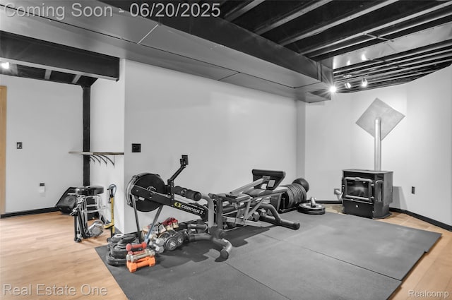 9806 Goldfinch Ct, Saline, MI 48176 - exercise area featuring a wood stove and wood finished floors
