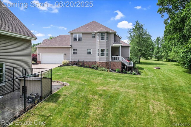 9806 Goldfinch Ct, Saline, MI 48176 - rear view of house featuring an attached garage, driveway, and a shingled roof