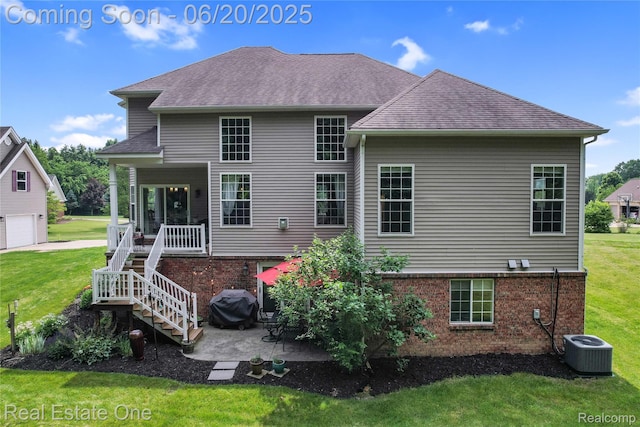 9806 Goldfinch Ct, Saline, MI 48176 - rear view of property with a lawn, brick siding, a shingled roof, and a patio area