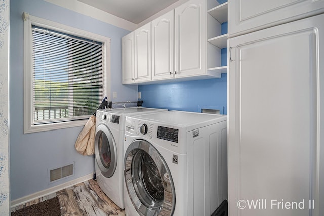 10296 S Lakeside Ridge Rd, Baldwin, MI 49304 - laundry area featuring cabinet space, washing machine and dryer, and wood finished floors