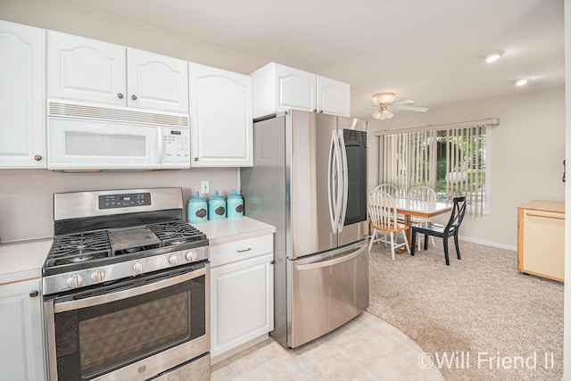 10296 S Lakeside Ridge Rd, Baldwin, MI 49304 - kitchen with appliances with stainless steel finishes, light carpet, white cabinets, light countertops, and a ceiling fan