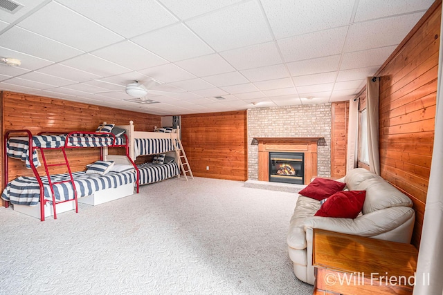 10296 S Lakeside Ridge Rd, Baldwin, MI 49304 - bedroom featuring wooden walls, carpet floors, a brick fireplace, and a drop ceiling