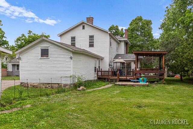 409 Rust Ave, Big Rapids, MI 49307 - back of property featuring a deck and a chimney
