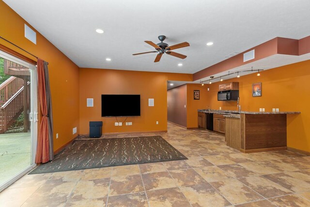 1995 Shining Tree Dr NE, Belmont, MI 49306 - kitchen featuring black appliances, rail lighting, ceiling fan, brown cabinetry, and stone countertops