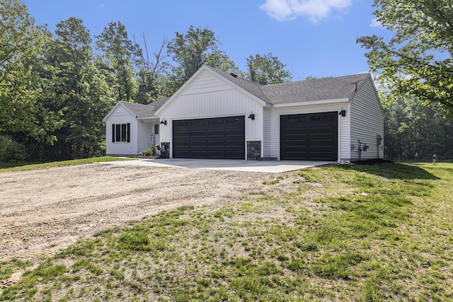 8114 E 72nd St # 2, Newaygo, MI 49337 - modern inspired farmhouse featuring driveway, a garage, a front yard, board and batten siding, and stone siding