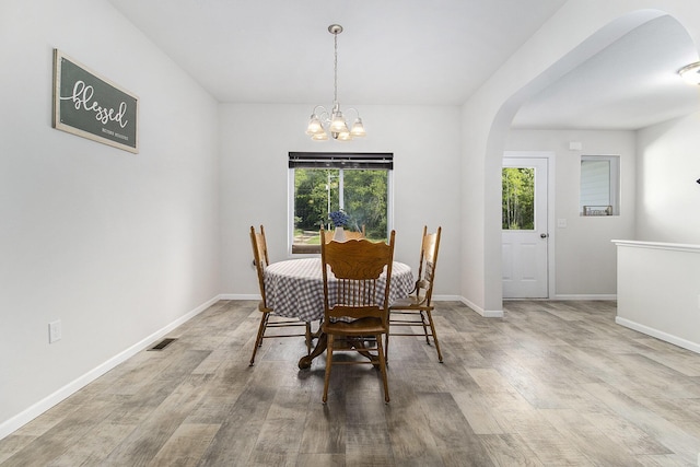 8114 E 72nd St # 2, Newaygo, MI 49337 - dining space with arched walkways, wood finished floors, and a chandelier