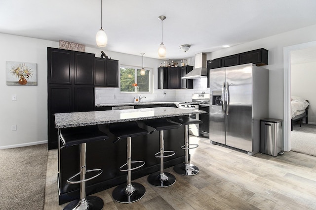 8114 E 72nd St # 2, Newaygo, MI 49337 - kitchen with appliances with stainless steel finishes, wall chimney exhaust hood, light stone countertops, and decorative backsplash