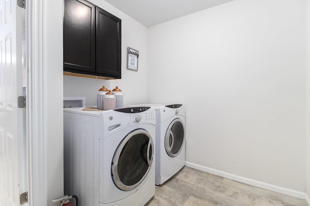 8114 E 72nd St # 2, Newaygo, MI 49337 - washroom with cabinet space, separate washer and dryer, and light wood finished floors