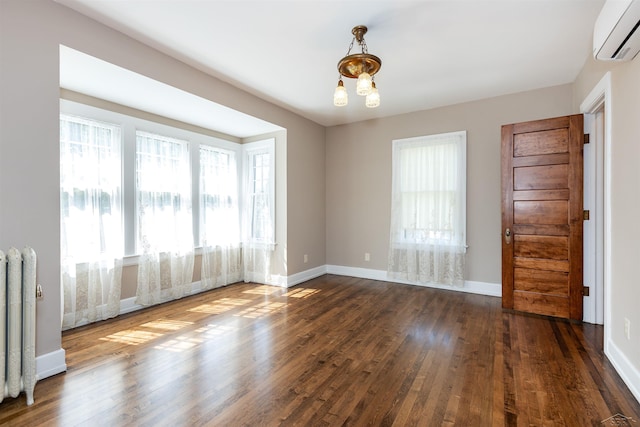 820 N Johnson St, Bay City, MI 48708 - empty room with a wall unit AC, radiator, and dark wood-style flooring
