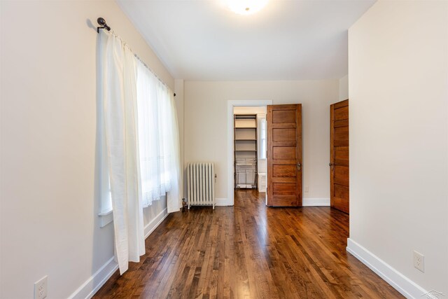 820 N Johnson St, Bay City, MI 48708 - unfurnished bedroom featuring radiator and dark wood finished floors