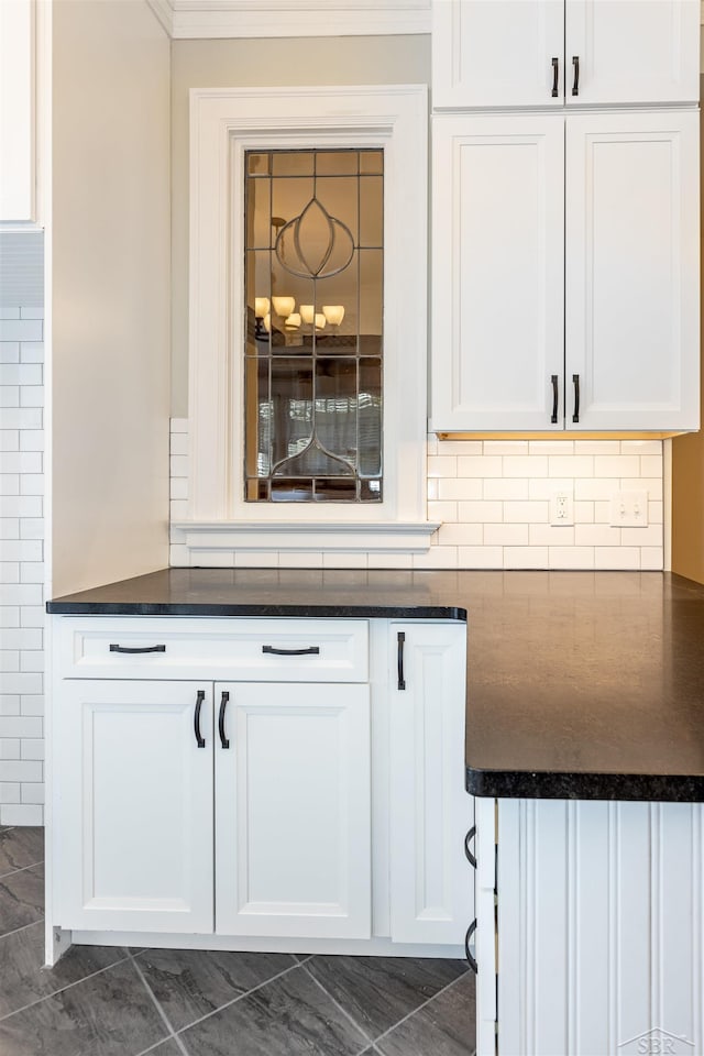 820 N Johnson St, Bay City, MI 48708 - kitchen featuring dark countertops, white cabinetry, ornamental molding, and decorative backsplash