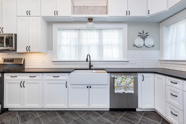820 N Johnson St, Bay City, MI 48708 - kitchen with stainless steel appliances, dark countertops, white cabinetry, and tasteful backsplash