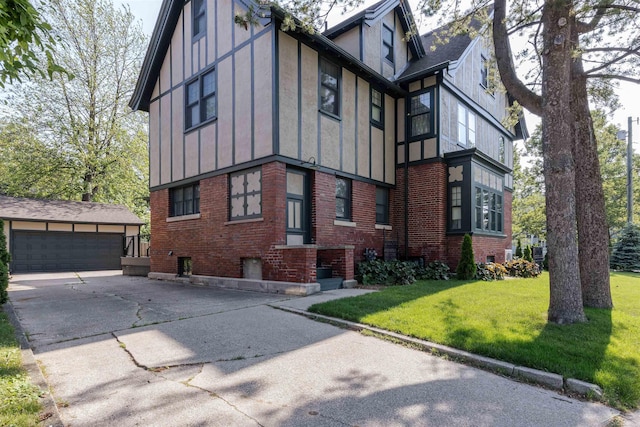 820 N Johnson St, Bay City, MI 48708 - view of side of property with brick siding, an outdoor structure, a detached garage, a yard, and board and batten siding