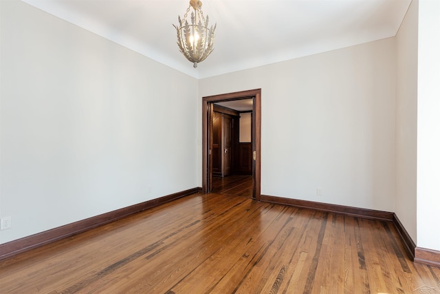 820 N Johnson St, Bay City, MI 48708 - spare room featuring hardwood / wood-style floors and a chandelier