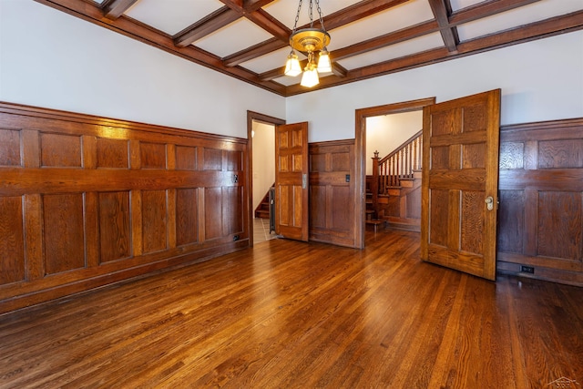 820 N Johnson St, Bay City, MI 48708 - unfurnished bedroom with coffered ceiling, beamed ceiling, wood finished floors, wainscoting, and wooden walls
