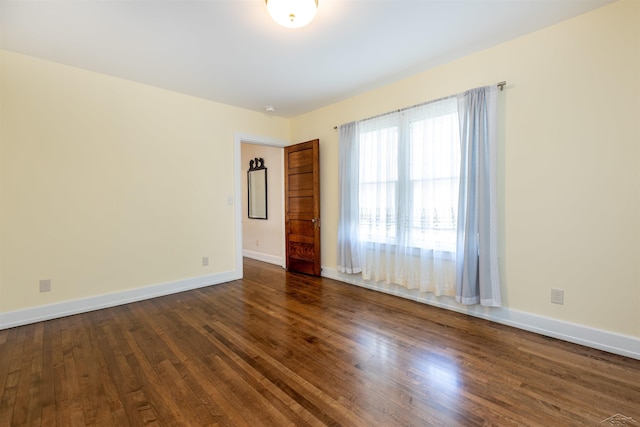 820 N Johnson St, Bay City, MI 48708 - spare room featuring dark wood-type flooring and baseboards