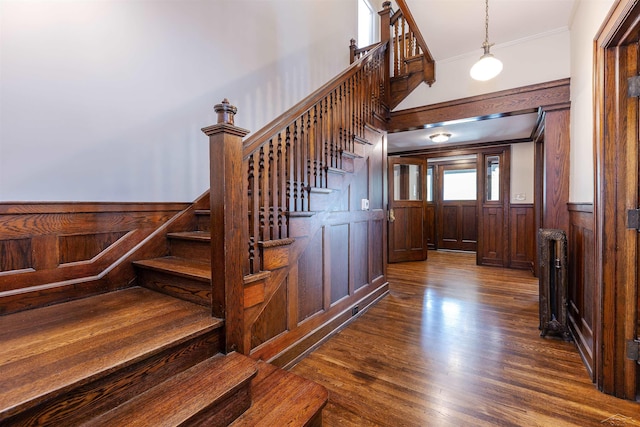 820 N Johnson St, Bay City, MI 48708 - staircase with ornamental molding, wainscoting, wood finished floors, wood walls, and radiator
